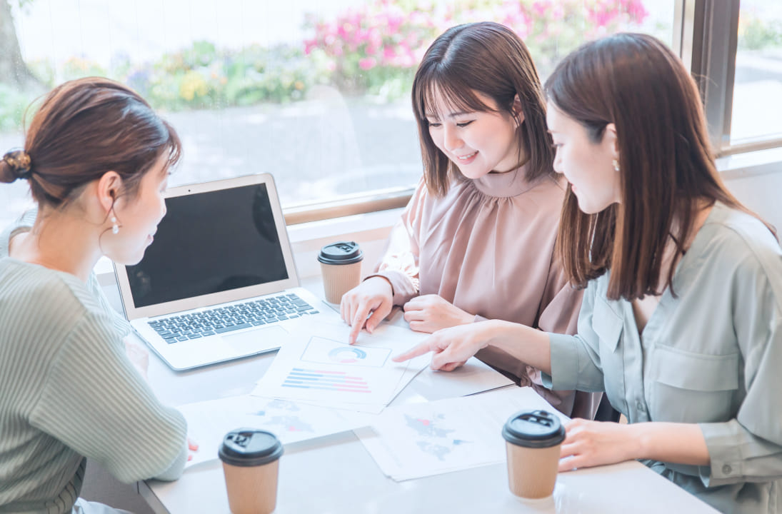資料を見て会議をする女性たち